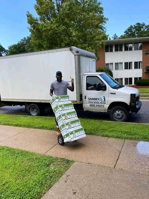 Sammy with a loaded hand truck beside the moving truck